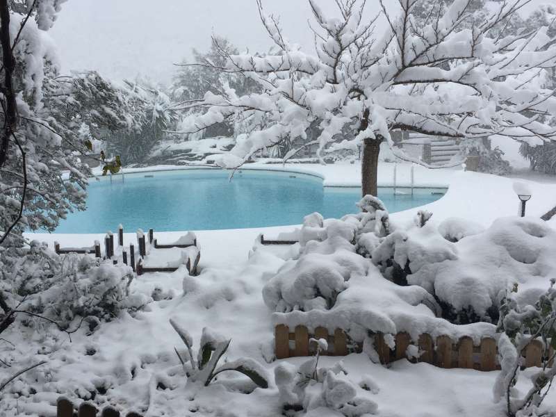 Αλλαγή νερού πισίνας. Μια χιονισμένη πισίνα στην κορυφή ενός λόφου