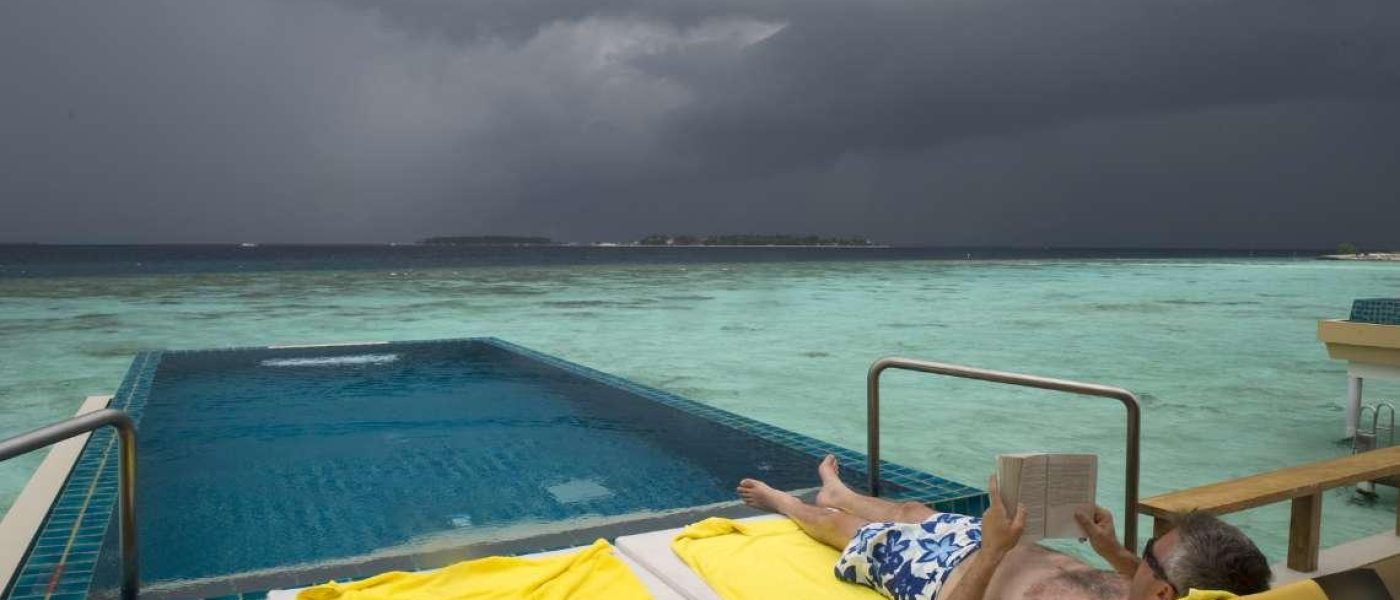 Πισίνα και καταιγίδα. Ένας κολύμβητής αγνοεί την καταιγίδα που έρχεται.