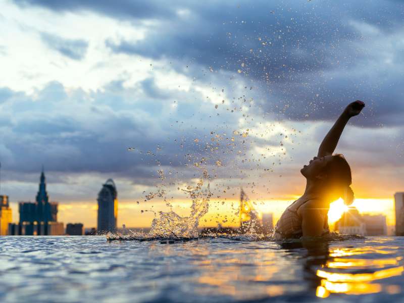 Πισίνα και καταιγίδα. Μια κολυμβήτρια που απολαμβάνει τη πισίνα παρά τον άσχημο καιρό.